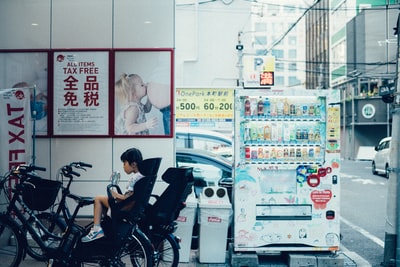 蹒跚学步的孩子在白衬衫坐在推车
